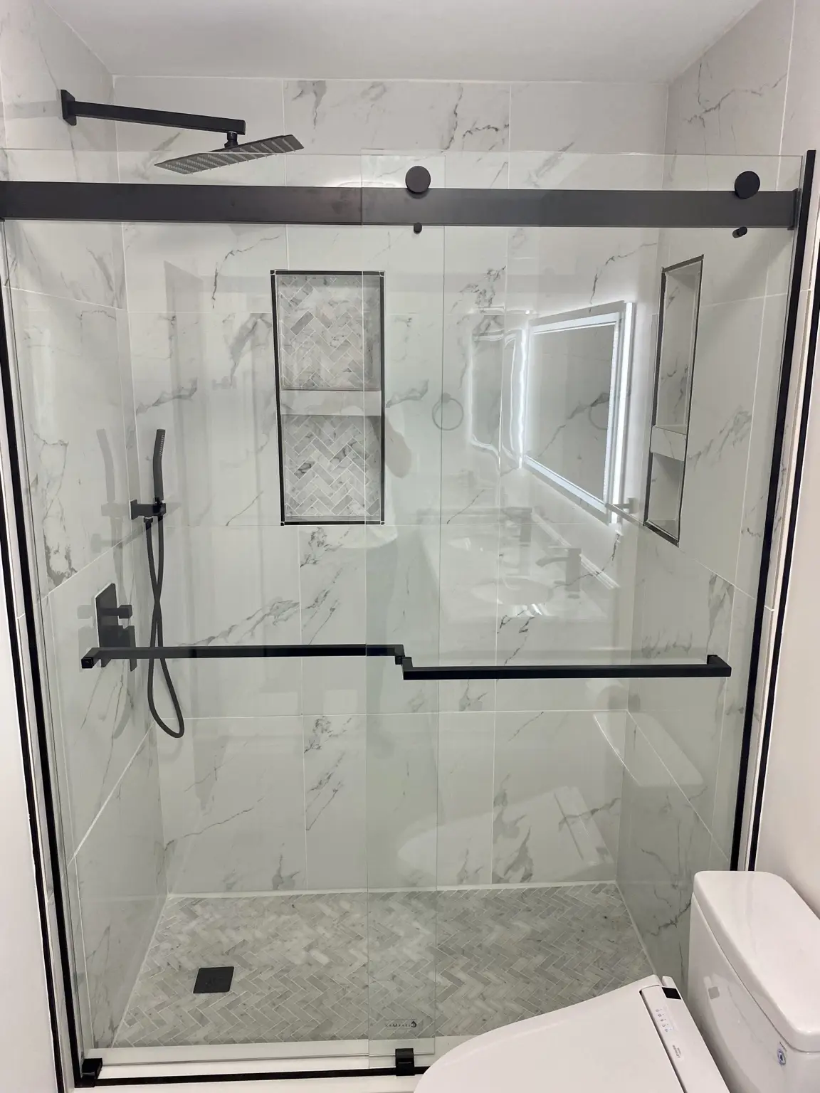 Marble-look tile walk-in shower with black fixtures